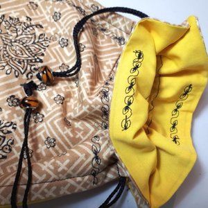 Handcrafted beaded cotton gift bag. 8" x 10". Cinch closure. 100% cotton.